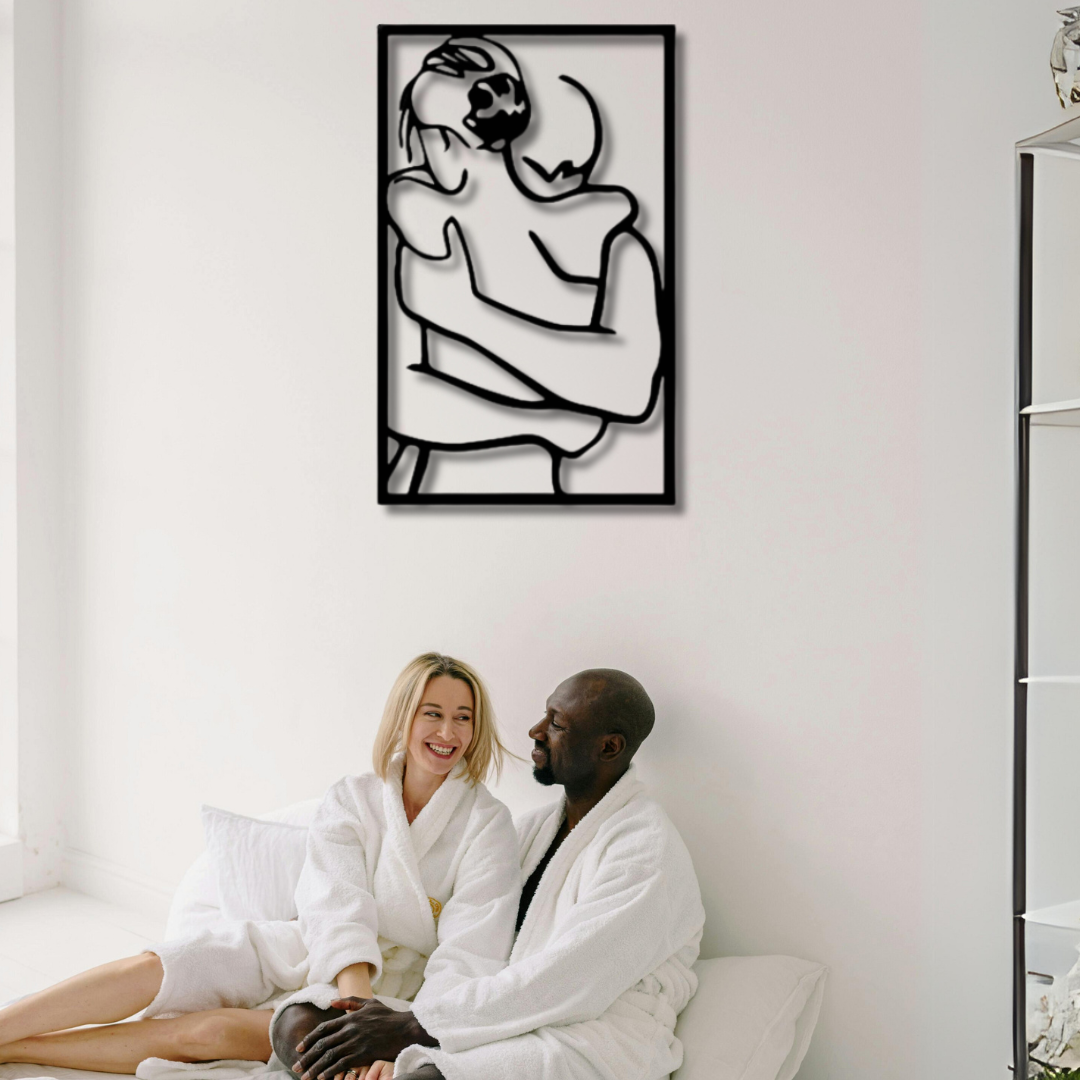 لوحة فنية معدنية على الحائط تصور زوجين يحتضنان بعضهما