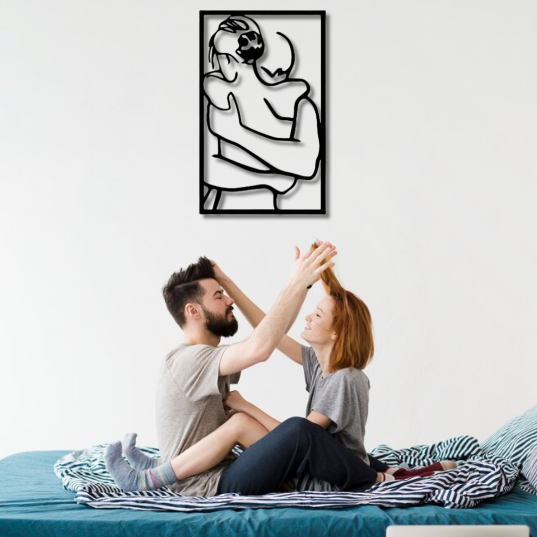 لوحة فنية معدنية على الحائط تصور زوجين يحتضنان بعضهما